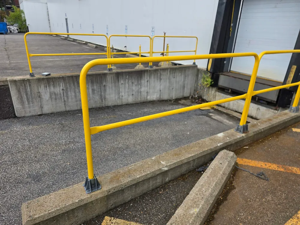 Garde-corps en acier peint jaune sur un stationnement